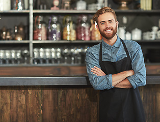 Image showing Confidence, industry and portrait of male barista standing by the counter in his startup cafeteria. Smile, success and young man with crossed arms with a small business coffee shop or restaurant.