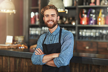 Image showing Happy, smile and portrait of coffee shop owner standing by the counter in his startup cafeteria. Happiness, success and male barista with small business with crossed arms for confidence in restaurant