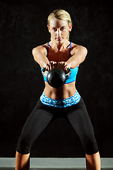 Image showing Woman in portrait, kettlebell and weightlifting with fitness, bodybuilder and workout in gym with active person. Exercise, focus and serious female athlete with determination and muscle training