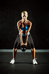 Image showing Woman, kettlebell and weightlifting with bodybuilder, exercise and workout in gym, healthy and active person. Portrait, focus and serious female athlete with determination, health and muscle training