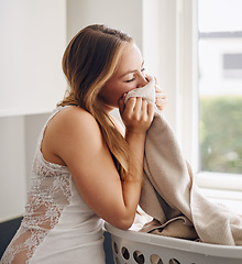 Image showing Smelling, woman and laundry with clothes in basket and happy with clean apartment towel. Female person, cleaning or fabric for self care, lifestyle and happiness in a household with fresh clothing.