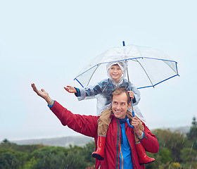 Image showing Umbrella, father and child in rain for family fun, happiness and quality time. Happy man and boy kid outdoor in nature with hand to catch water drops for freedom, learning and play with sky mockup