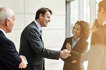 Image showing Group, professional and negotiation with handshake for agreement with conversation at the office. Business, people and welcome partner in the lobby for a discussion about contract in the company.