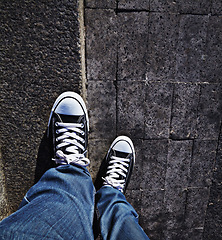 Image showing Pov, shoes and man in a road for travel, weekend and fun in a city alone. Above, feet and male in a street with sneakers outdoors for walking, commute or solo travelling while exploring town on foot