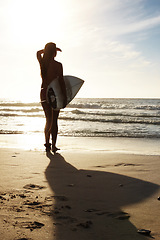 Image showing Silhouette, woman surfer on beach sand and sea, exercise outdoor and healthy with surfboard and scenic ocean view Sports, shadow and sun with female person in nature and ready to surf for fitness