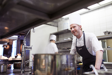 Image showing Commercial, man and chef in a kitchen, service and order preparation for meal during dinner rush. Male person, restaurant and professional with planning, food industry and catering with hospitality