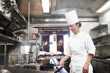 Image showing Restaurant, cooking and a woman chef in the kitchen for luxury hospitality or preparation of a gourmet meal. Food, catering and a professional female cook working in the commercial service industry