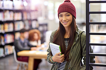 Image showing Woman in portrait, student in library with book and study for exam with smile on university campus. Education, learning and academic development with female person holding textbook for knowledge