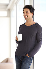 Image showing Happy, smile and man with a cup of coffee standing by the window in a vacation house. Calm, relax and attractive male person drinking a latte in a mug in the living room while thinking or in a dream.