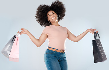 Image showing Woman, jump and excited with shopping bag and smile in portrait, retail and happy customer on studio background. Happiness over sale, discount or promotion, female person in air and luxury fashion