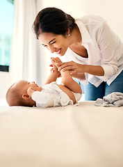 Image showing Smile, love and a mother with her baby in the bedroom of their home together for playful bonding. Family, kids and a happy young mama spending time with her newborn infant on the bed for fun or joy