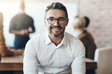 Image showing Leadership, portrait of ceo or businessman smile and sitting in office at work with colleagues behind manager. Entrepreneur or business, leader and smiling male person with glasses sit at workplace