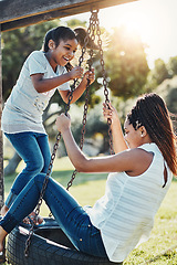 Image showing Mother with daughter on swing at park, fun playing together with happiness and carefree outdoor. Love, care and bonding with family in nature, woman and girl enjoying time at playground with freedom