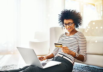 Image showing Young woman, laptop and credit card with bokeh doing online shopping sitting on ground. Home, happiness and computer of happy African female person on a web ecommerce app reading an internet deal