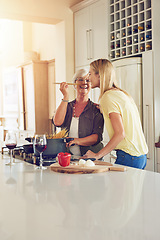 Image showing Taste, woman or happy mother cooking food for a healthy vegan diet together with love in family home. Smile, tasting or adult daughter eating or helping senior mom in house kitchen at lunch or dinner