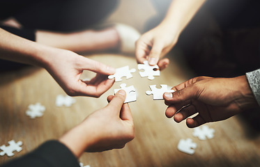 Image showing Hands, business people and puzzle in circle, closeup and teamwork for problem solving, solution and game. Group, together and helping hand for jigsaw, solidarity and team building on office floor