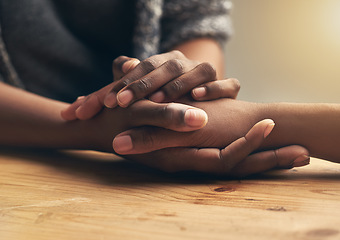 Image showing Comfort, sympathy and people holding hands for unity, compassion and cancer support at wood table. Empathy, care and couple or friends with affection in bonding moment together for grief and loss.