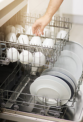 Image showing Dishwasher machine, cleaning and hands of person washing dirty kitchenware for easy housekeeping, hygiene and housework. Closeup of electrical appliance for dishes, cups and plates in kitchen at home