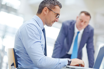 Image showing Business man, laptop or research for talking colleague, question or review for job or work performance at desk. Corporate boss, employees or people in discussion on computer or information technology