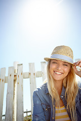 Image showing Woman, hat and portrait in sunshine, blue sky background or mockup lens flare. Summer fashion, park and female relax at field fence, nature and freedom with happiness in environment, mock up or smile