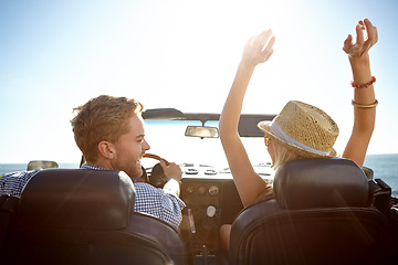 Image showing Car, road trip and freedom with a couple by the beach on a drive to enjoy the view during summer together. Travel, transport and driver with a woman sitting hands raised by the ocean with her man