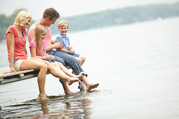 Image showing Holiday, lake and family with kids with foot in water during summer vacation in the outdoor with space. Deck, parent and child at an adventure together with sunshine and freedom to travel in mock up.