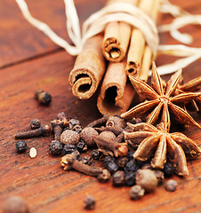 Image showing Indian spices, cooking ingredient and table with kitchen herbs for curry and biryani. Wood tabletop, healthy diet and closeup with cinnamon, pepper and cloves for Mediterranean cuisine with cumin