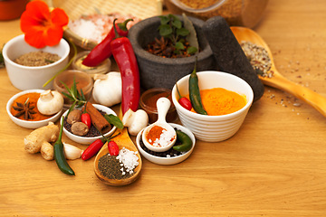 Image showing Mortar, food and spices on table for cooking gourmet meal, chili seasoning or flavor pestle. Pepper vegetables, kitchen condiments and variety of plant herbs for brunch, healthy diet or vitamins.