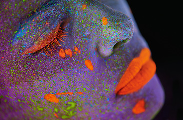 Image showing Neon paint, beauty and woman face closeup with dark background and creative cosmetics. Glow makeup, fantasy and psychedelic cosmetic of a female model with unique and creativity with art in studio