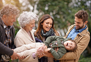 Image showing Happy family, child and parents in happiness with kid in a park on outdoor vacation, holiday and excited together. Grandparents, happiness and people play as love, care and bonding in nature