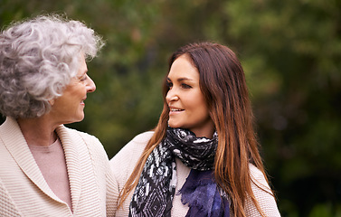 Image showing Talking, outdoor and woman with elderly mother together on a nature vacation or holiday bonding in happiness. Retirement, women and young happy female person in conversation and with mom in a garden
