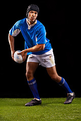 Image showing Rugby, dark and man sports athlete pass a ball at night in black studio background training, wellness and fitness. Exercise, workout and professional career of sport male person or player on grass