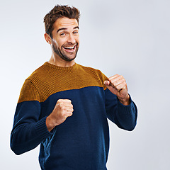 Image showing Portrait, winner and man with energy, fist and excitement with guy isolated against a studio background. Face, male person and model winning, goals and happiness with victory, wow and omg with joy