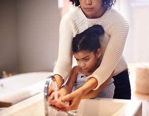 Image showing Cleaning, water and washing hands by mother and child in a bathroom for learning, hygiene and care. Basin, wash and hand protection by mom and girl together for prevention of bacteria, dirt and germs