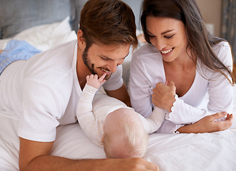 Image showing Mom, dad and baby in bedroom for love, care and quality time together. Happy family, parents and newborn child relaxing on bed with smile, childhood development and support to nurture kids at home