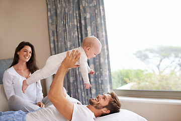 Image showing Happy family playing with baby in air, bedroom and fun of love, care and quality time to relax together at home. Mom, dad and holding playful infant kid for happiness, support and newborn development