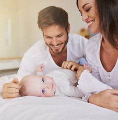 Image showing Happy family, baby and parents on bed for love, care and quality time together in house. Mom, dad and cute newborn kid relax in bedroom of home for childhood development, caring support and happiness