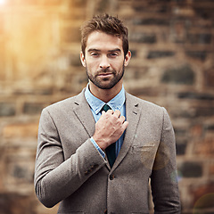 Image showing Business man, portrait and urban wall with fashion, confidence and success in entrepreneurship. Young businessman, entrepreneur and suit in street, city or sidewalk with focus, style and motivation