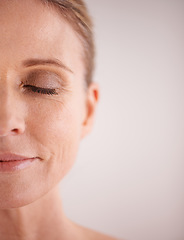 Image showing Skin care, mockup and half with a woman face in studio on a gray background for cosmetic beauty advertising. Facial, wellness and eyes closed with a senior female model posing for natural skincare