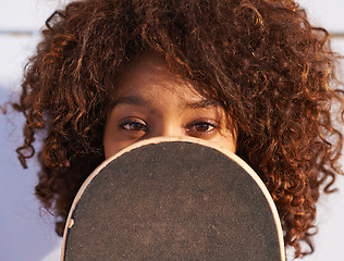 Image showing Eyes, cover and portrait of woman with skateboard for fitness, urban and hiding in outdoors. Training, skating and youth with face of female skater in park for hipster, relax and skateboarder