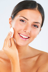 Image showing Portrait of a woman with a cotton pad for skincare in studio for a beauty, natural and face routine. Health, wellness and happy female model with cosmetic facial product isolated by white background.