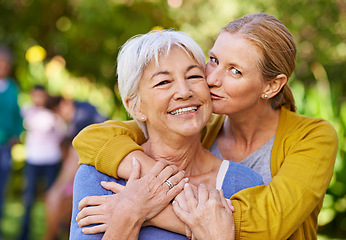 Image showing Senior mother, woman and kiss in nature, outdoor and portrait with love, care and trees on holiday. Elderly mama, lady and embrace with bond, excited face and support in backyard with summer sunshine