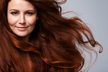 Image showing Redhead, wind and hair portrait of woman in studio for treatment, wellness and beauty on gray background. Salon, hairdresser and happy face of female model with shine, healthy and natural hairstyle