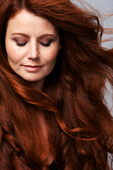 Image showing Hair, beauty and face of redhead woman in studio for keratin treatment, wellness and haircare on gray background. Salon, hairdresser and female model with natural shine, healthy and red hairstyle