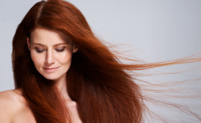 Image showing Hair care, red head and woman with wind for keratin treatment, wellness and beauty on white background. Salon, hairdresser and female model face with shine, healthy and natural hairstyle in studio