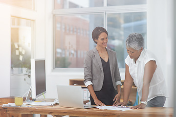 Image showing Business women, desk and discussion in office for planning, proposal or advice. Corporate team or manager and employee together for collaboration or teamwork while talking about paperwork or report