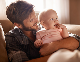 Image showing Smile, dad and hug baby on sofa in home living room, playing or bonding together. Happiness, care and father embrace infant, newborn or child on couch in lounge, having fun and enjoying quality time.