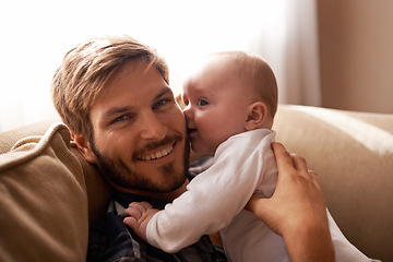 Image showing Smile, father and face with baby on sofa in home living room, playing or bonding together. Kiss, care and dad with infant, newborn or child on couch in lounge, having fun or enjoying quality time