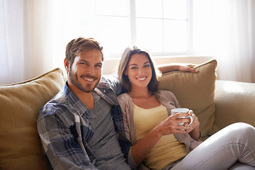 Image showing Portrait, coffee and couple relax or smile on a couch together or bonding in the living room and with tea. Man, woman and love or affection with hot beverages or on a break and happy partners at home