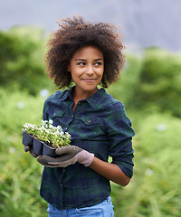 Image showing Black woman in garden, smile while gardening with flowers and botany, young gardener outdoor and environment. Happy female person with green fingers, growth and plants in nature with landscaping